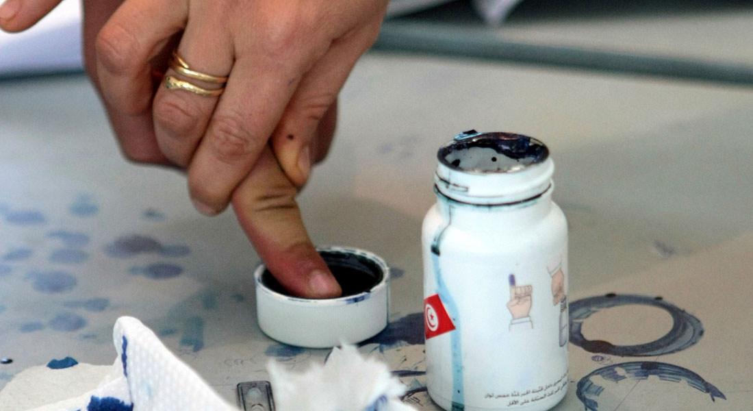 A woman marks one of her finger with ind